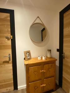 un espejo en una pared junto a un tocador de madera en Les bouquetins, en La Clusaz