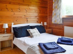 a bedroom with a bed with blue towels on it at Edw Lodge in Aberedw