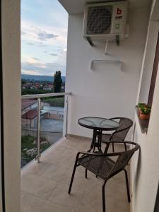 a table and chairs on a balcony with a view at Apartman Remeta in Banja Koviljača
