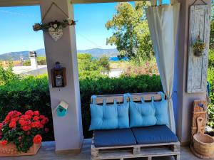 a blue bench sitting on a porch with flowers at Nido Gagà in Capoliveri