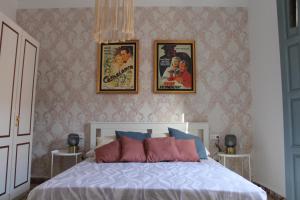 um quarto com uma cama com três fotografias na parede em Caserón Centenario em Cehegín