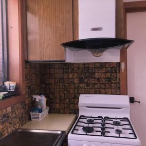 uma cozinha com um fogão branco e um micro-ondas em Golden House em Springvale