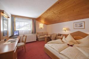 ein Hotelzimmer mit einem Bett und einem Schreibtisch in der Unterkunft Hotel Jagdhof Bed & Breakfast in Obergurgl