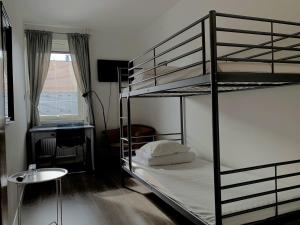 a bedroom with two bunk beds and a desk at Solsta Hotell in Karlstad