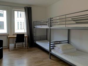 a room with two bunk beds and a desk at Solsta Hotell in Karlstad