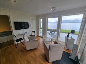 a living room with a view of the water at feriehus ved sjøen in Tomrefjord