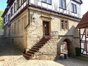 um antigo edifício de pedra com escadas que levam a uma porta em LA PETITE MAISON Fachwerkhaus am Rande des Sauerlandes in Warburg em Warburg