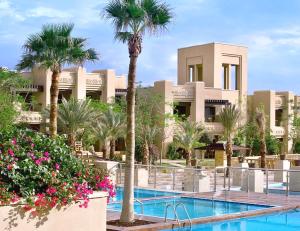 a resort with a swimming pool and palm trees at Holiday Inn Resort Dead Sea, an IHG Hotel in Sowayma