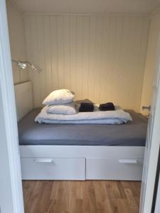łóżko z 2 poduszkami w pokoju w obiekcie feriehus ved sjøen w mieście Tomrefjord