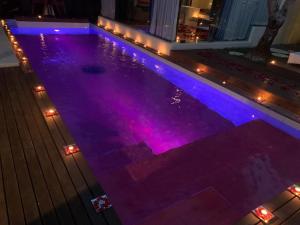 una piscina con luces moradas en una casa en Kiss Bali Villas, en Seminyak