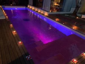 uma piscina com luzes roxas numa casa em Kiss Bali Villas em Seminyak