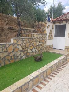 pared de piedra y patio con puerta blanca en Darolio Biofarm en Petalidhion