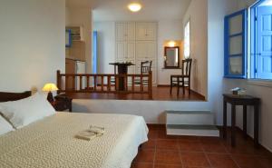 a bedroom with a bed and a living room with a kitchen at Belvedere Apartments in Chora Folegandros