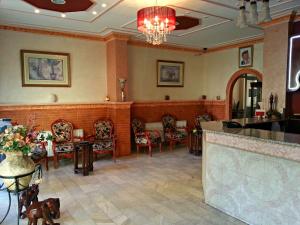 a lobby with chairs and a bar in a building at Sufara Hotel Suites in Amman