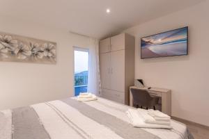 a bedroom with a bed and a desk and a window at Secluded house - guaranteed privacy in Klis