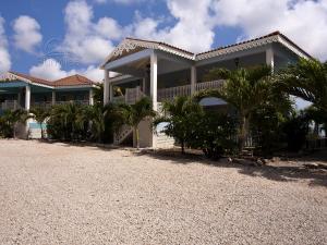 a large house with palm trees in front of it at Imperial Breeze in Kralendijk