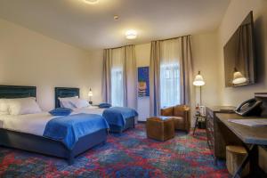 um quarto de hotel com duas camas e uma secretária em La Boheme em Bucareste