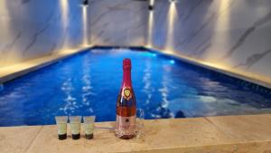 uma garrafa de champanhe ao lado de uma piscina em Lago Suites Hotel em Jerusalém