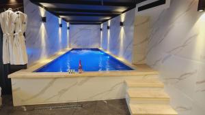 uma grande piscina num quarto com piso de pedra em Lago Suites Hotel em Jerusalém