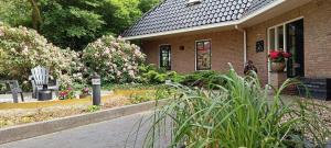 a brick house with flowers in front of it at Rembrandthuis in Ommen
