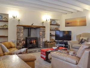 a living room with a fireplace and a tv at Middleton Hall in Rhossili