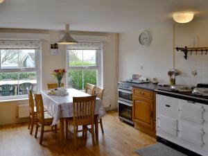 a kitchen with a table and chairs and a kitchen with a stove at Middleton Hall in Rhossili