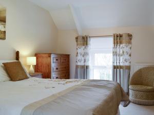 um quarto com uma cama grande e uma janela em Middleton Hall em Rhossili