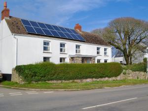 a white house with solar panels on the roof at Middleton Hall in Rhossili