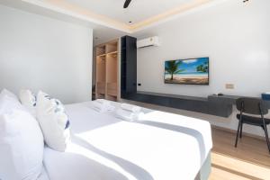 um quarto com uma cama branca e uma secretária em By The Beach Home in Patong em Praia de Patong