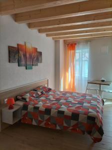 1 dormitorio con cama, mesa y ventana en B&B Al Portico, en Telve