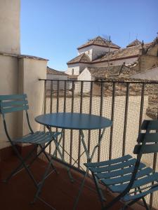einen Tisch und zwei Stühle auf dem Balkon in der Unterkunft Apartamentos Acevedo Centro I in Ronda