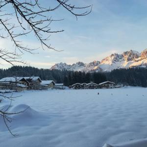 zamarznięte jezioro z domami i pokrytymi śniegiem górami w obiekcie Josef Foidl (Bairerbauer) w mieście Oberndorf in Tirol
