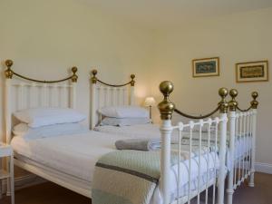 two twin beds in a bedroom with white walls at The Bothy in Blewbury