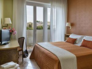 um quarto de hotel com uma cama e uma janela em Parioli Hotel Rimini em Rimini