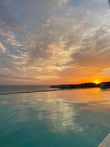 una piscina d'acqua con il tramonto sullo sfondo di Villa Gentile a Eraclea Minoa