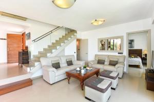 una sala de estar con muebles blancos y una escalera. en Holiday Home Villa Gema, spacious, scenic, Wlan ,AC en Maspalomas