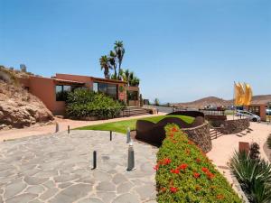 a house with a garden with flowers in front of it at Holiday Home Villa Gema, spacious, scenic, Wlan ,AC in Maspalomas