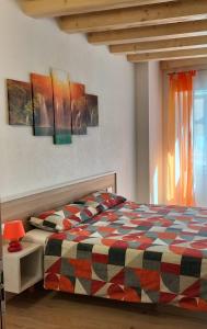 una camera con un letto con una coperta a scacchi di B&B Al Portico a Telve