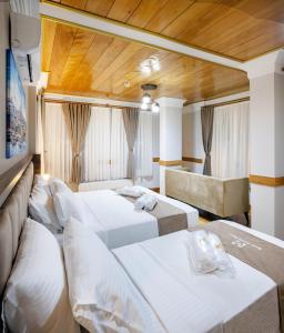 HOME QUALITY HOTEL في إسطنبول: غرفة فندقية بثلاث اسرة واريكة