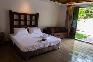 a bedroom with a large bed and a couch at GIARDINO ROMANTICO in Dumaguete