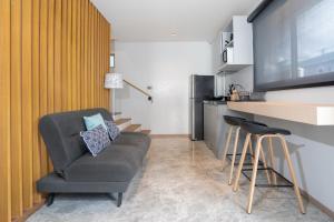 a living room with a couch and a television at By The Beach Home in Patong in Patong Beach