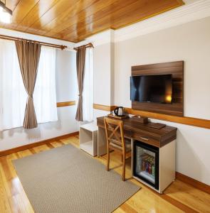 HOME QUALITY HOTEL في إسطنبول: غرفة معيشة بها موقد وتلفزيون بشاشة مسطحة