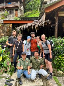 a group of people posing for a picture in front of a house at Lawang Inn in Bukit Lawang