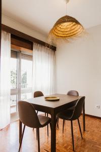 een eettafel met stoelen en een kroonluchter bij Apartamento Santos Pousada in Porto