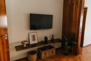 Una sala de estar con un televisor de pantalla plana en una pared. en Apartamento Santos Pousada, en Oporto