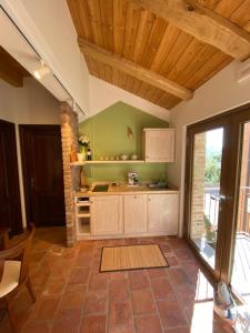 a kitchen with wooden ceilings and a large window at Cascina Maina in Diano dʼAlba