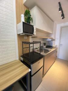eine kleine Küche mit einer Theke und einer Mikrowelle in der Unterkunft Comfy Studio unit with Wi-fi, Las Piňas City, parking rent optional in Manila
