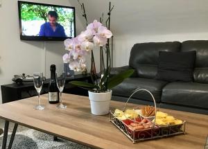 a coffee table with a basket of fruit and wine glasses at Alfie’s home in Malmedy