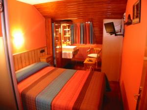 a bedroom with a bed and a bathroom with a sink at Hotel Navarro in Panticosa