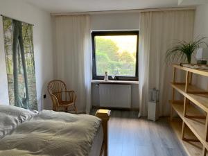 um quarto com uma cama e uma janela em Eifeloase Sophia em Nettersheim